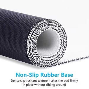 May include: Rolled-up black mouse pad with a white interior and a non-slip rubber base. The pad has a dense, textured surface. The text "Non-Slip Rubber Base" is visible in the image.