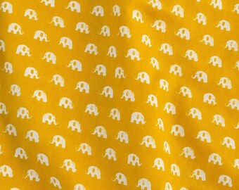 Peut inclure: Un tissu jaune moutarde vibrant présentant un motif répétitif de petites silhouettes d'éléphants blanches et stylisées, disposées en rangées diagonales sur toute la surface, créant un design graphique uniforme et cohérent sur le textile.
