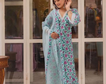 May include: A light blue floral print kurta set with a matching dupatta. The ensemble features a V-neckline and is adorned with pink floral patterns. The outfit is worn with clear sandals.