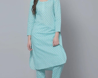 May include: A light blue two-piece pajama set with a white floral pattern. The long-sleeved top has a scoop neck and the pants are cropped. The model is wearing white sandals. The outfit is made of a soft, lightweight fabric.