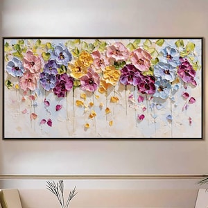 Puede incluir: Pintura floral enmarcada con una variedad de flores coloridas en tonos rosa, morado, amarillo y azul. La obra de arte texturizada tiene un fondo blanco y un marco negro, adecuada para la decoración del hogar.