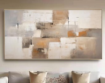Könnte beinhalten: Abstrakte rechteckige Wandkunst mit goldenem Rahmen. Das Kunstwerk zeigt eine neutrale Farbpalette aus Weiß, Beige und Braun mit geometrischen Formen und Pinselstrichen. Es hängt über einem weißen Sofa.