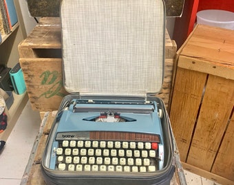 Vintage Brother Opus 888 Tabulator Typewriter in Blue w/Handled Travel Case. Typewriter Measures 12”x12”x3.5” & Case Measures 13”x1”x5”