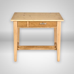 Könnte beinhalten: Ein Schreibtisch aus hellem Holz mit einer rechteckigen Tischplatte, die sichtbare Holzmaserungen und Astlöcher aufweist. Der Tisch verfügt über eine einzelne horizontale Schublade mit einem kleinen silbernen Metallgriff, vier gerade Beine und eine untere Querstrebe.