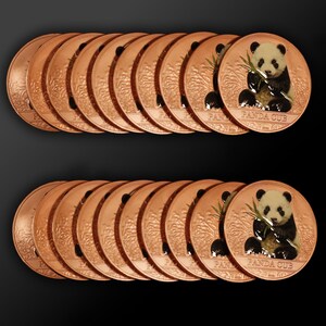 May include: A collection of round copper-colored medallions arranged in two rows. Each medallion features a relief image of a panda cub eating bamboo, with the text PANDA CUB printed at the bottom. The surface has a metallic finish.