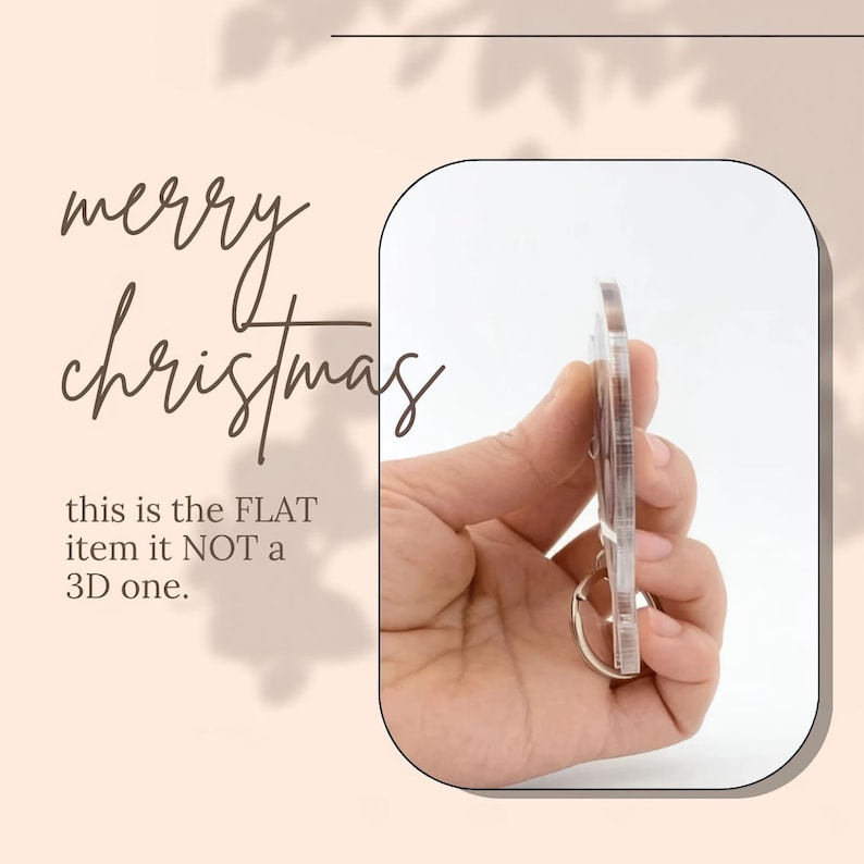 May include: Clear acrylic Christmas-themed keyring with a silver ring. The keyring is held in a hand, and the text "merry christmas" is visible in the background. The text "this is the FLAT item it NOT a 3D one" is also visible.