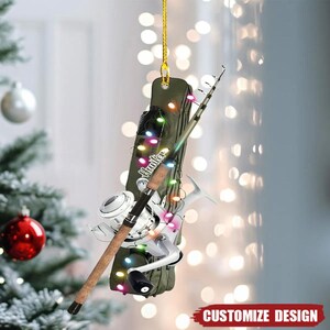 May include: A fishing-themed Christmas ornament with a fishing rod, reel, and a green case. The ornament is decorated with colourful lights and the word "Hunter". The bottom right corner has the text "CUSTOMIZE DESIGN".
