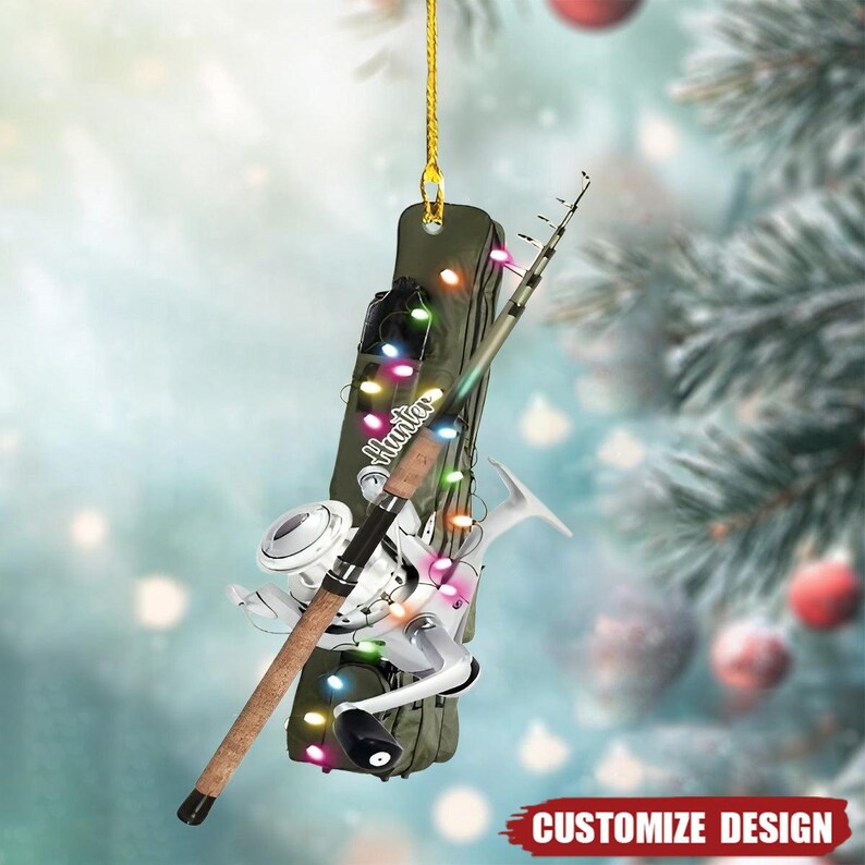 May include: A Christmas tree ornament with a fishing theme. It features a fishing rod, reel, and a green case with the word "Hunter". The ornament is decorated with colourful string lights and a gold hanging string. The words "Customize Design" are at the bottom.