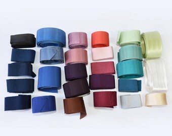 May include: A collection of colorful ribbons in various shades, including black, blue, pink, red, green, and beige. The ribbons are arranged on a white surface, showcasing their different textures and colors. Ideal for crafting, gift wrapping, or decorative purposes.
