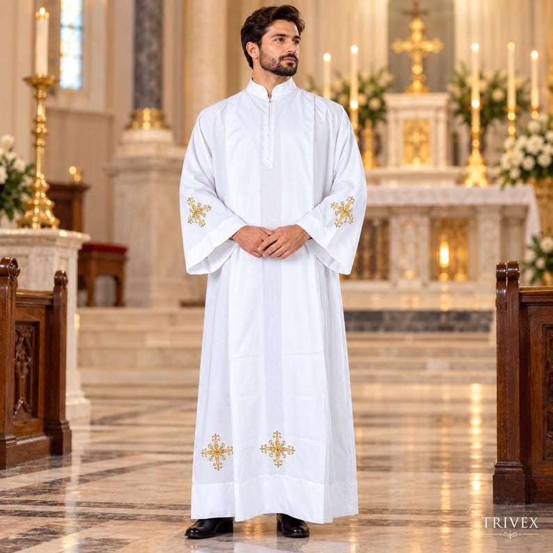May include: A white liturgical alb featuring a high collar, long sleeves, and gold embroidered cross motifs on the cuffs and lower hem. The garment is floor-length with a structured fit and a vertical placket detail at the center of the chest.