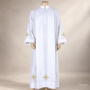 May include: A white liturgical alb featuring a mandarin collar and a front zipper closure. The garment is decorated with gold and silver embroidered cross motifs positioned on the lower hem and on the outer side of each wide sleeve cuff.