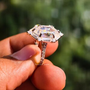 A high-resolution macro photography shot of the brilliant Dutch marquise moissanite center stone. The sunlight highlights the unique hexagon faceting and exceptional VVS1 clarity, casting dazzling light reflections and intense fire. The secure prongs and hidden micro-pave detailing are shown in high resolution, proving the premium materials and precise setting techniques used for this high-end proposal ring
