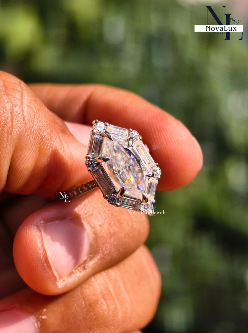 An image of the NovaLux Jewels Dutch marquise ring held up to demonstrate scale and its unique, slenderizing effect on the hand. The geometric stone creates a sophisticated focal point, while the dainty pave band adds to the modern minimalist aesthetic. Shimmering light reflections suggest a high-value anniversary or wedding gift that combines timeless elegance with contemporary design.