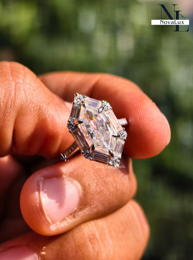 An image of the NovaLux Jewels Dutch marquise ring held up to demonstrate scale and its unique, slenderizing effect on the hand. The geometric stone creates a sophisticated focal point, while the dainty pave band adds to the modern minimalist aesthetic. Shimmering light reflections suggest a high-value anniversary or wedding gift that combines timeless elegance with contemporary design.