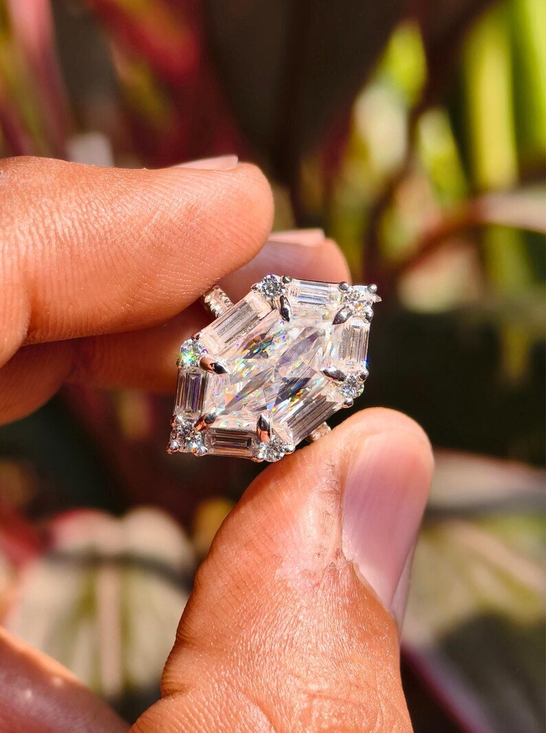 A variation of the Dutch marquise ring shown in 14k yellow gold to highlight the "Golden Glamor" trend. The warm gold metal enhances the bright white brilliance of the D-color moissanite, creating a regal and nostalgic aesthetic. The image focuses on the rich, golden hue of the band and its elegant, handcrafted curves as they meet the shimmering geometric center stone.