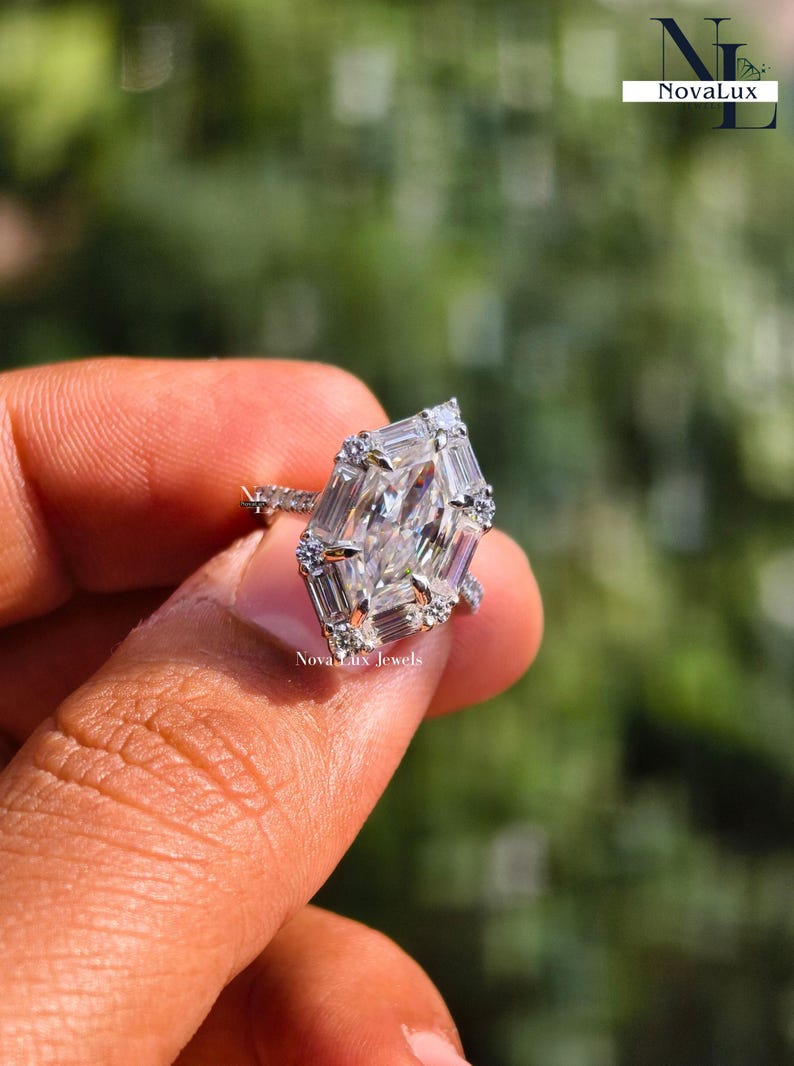 A romantic close-up of a sparkling moissanite engagement ring, symbolizing a modern love story that values both brilliance and ethical sourcing. The colorless D-color stone reflects only pure white light against the bright white gold setting. The soft-focus greenery in the background reinforces the brand's commitment to "Quiet Luxury" and sustainable, handcrafted elegance for the contemporary bride.