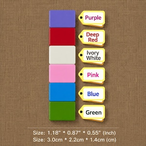 May include: A vertical stack of six rectangular blocks in purple, deep red, ivory white, pink, blue, and green. Each block has a corresponding yellow tag with the color name printed in text. The dimensions are 1.18 inches by 0.87 inches by 0.55 inches.