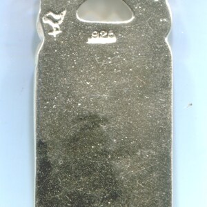 May include: Silver pendant with a detailed design and a 925 stamp on the back.