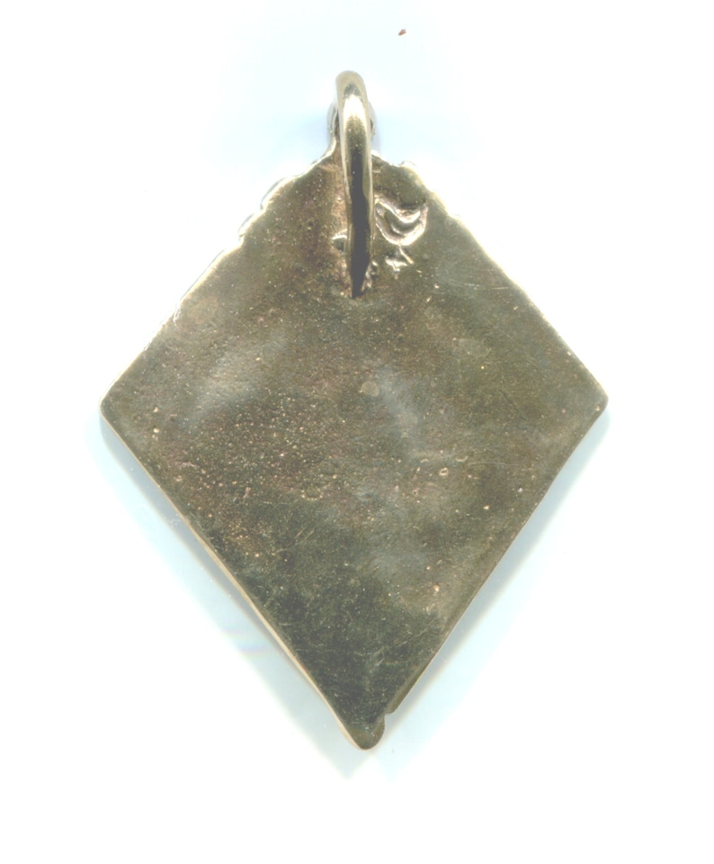 Puede incluir: Un colgante de color dorado en forma de diamante con un bucle en la parte superior para colgar. El colgante es liso y tiene una superficie ligeramente texturizada.