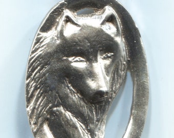 May include: Silver pendant featuring a detailed wolf head in profile, with a textured fur design. The pendant is oval shaped with a loop at the top for attaching a chain.