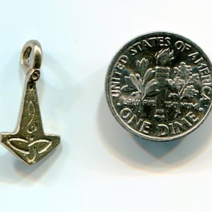 May include: Silver charm in the shape of a hammer with a Celtic knot design. The charm is about the size of a dime.