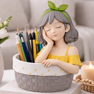 May include: A decorative pencil holder shaped like a girl with gray hair and a green bow. The girl is leaning on the edge of a gray basket-style container filled with pencils and pens. The container is sitting on a white surface.