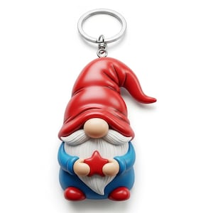 Op de afbeelding: Een kabouter sleutelhanger met een rode hoed, witte baard en blauw outfit. De kabouter houdt een rode ster vast en heeft een zilveren sleutelhanger. De hoed van de kabouter is gebogen en hij houdt een rode ster vast.