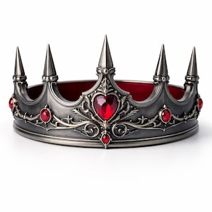 May include: A silver-colored crown with a red velvet interior and red jewel accents. The crown features pointed spikes and ornate detailing, with a heart-shaped jewel at the center. A decorative item.
