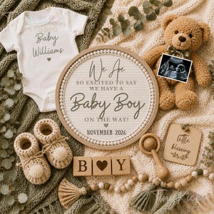 May include: A baby announcement featuring a white onesie with "Baby Williams" text, a letter board announcing "Baby Boy" for November 2026, and a teddy bear holding an ultrasound image. Includes knitted booties and wooden blocks.