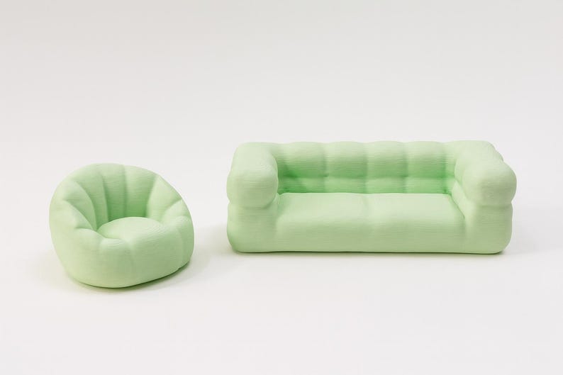Puede incluir: Un conjunto de muebles en miniatura de color verde claro, que incluye un sof&aacute; y un sill&oacute;n. El sof&aacute; tiene forma rectangular con respaldo y reposabrazos acolchados. El sill&oacute;n es redondo con respaldo curvo. Ambos son de color verde pastel.