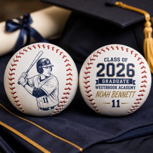 May include: Two baseballs with red stitching. One baseball features a baseball player illustration and the number 11. The other baseball says "Class of 2026 Graduate Westbrook Academy Noah Bennett - 11".