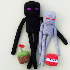 May include: Handmade crochet Minecraft characters: a black Enderman with purple eyes and a light purple Enderman with red eyes. Also included are a TNT block and a flower pot. These toys are suitable for children.