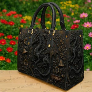 Może przedstawiać: Czarna torebka z detalicznym wzorem reliefu smoka. Torba posiada dwa górne uchwyty, złote okucia i tabliczkę z imieniem. Wzór smoka zawiera elementy kwiatowe i grzybowe.