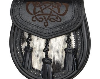 Peut inclure: Sporran en cuir noir avec un motif de nœud celtique sur le rabat. Le sporran présente un devant en fourrure blanche et grise, des glands noirs et des clous argentés sur les bords. Accessoire écossais traditionnel.
