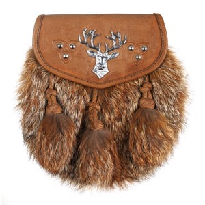 Puede incluir: Una sporran de cuero marr&oacute;n con un emblema de ciervo plateado y ribete de piel. La sporran tiene tres borlas marrones y detalles de nudos celtas. Este accesorio escoc&eacute;s tradicional se usa con un kilt.