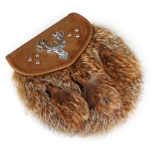 Puede incluir: Una sporran de cuero marr&oacute;n con un emblema de ciervo plateado y detalles de nudos celtas. La sporran presenta un cuerpo de piel y dos borlas decorativas. Este accesorio escoc&eacute;s tradicional se usa con un kilt.
