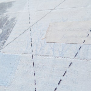 Pode incluir: Uma superf&iacute;cie branca texturizada com um peda&ccedil;o de papel colado nela. O papel tem uma escrita fraca nele. H&aacute; linhas tracejadas pretas desenhadas sobre a superf&iacute;cie.
