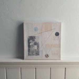 Pode incluir: Pintura abstrata em tela com fundo branco e formas geom&eacute;tricas em preto, cinza e azul. A pintura apresenta uma imagem em preto e branco de uma pessoa no centro.