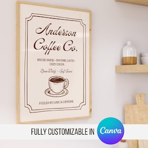 Könnte beinhalten: Ein gerahmter Druck mit dem Text "Anderson Coffee Co." in brauner Schrift. Der Druck enthält eine Kaffeetassen-Illustration und Sätze wie "House Brew" und "Cozy Cocoa". Der untere Teil des Drucks lautet "Fueled by Love & Caffeine."