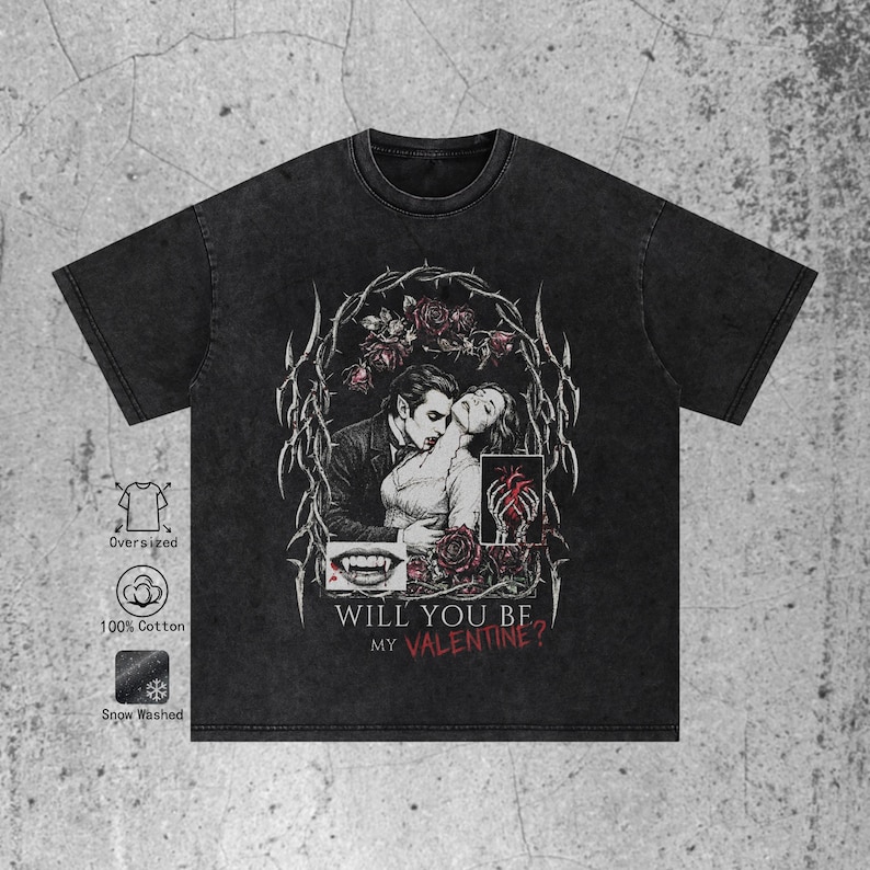 Flat lay of a premium black t-shirt featuring a dark romance vampire graphic. The shirt has a textured washed and a relaxed streetwear fit. The central print depicts a vampire biting a woman's neck, framed by withered roses and sharp cyber sigilism tribal thorns. Below the illustration, grunge text in white and blood red reads "WILL YOU BE MY VALENTINE?". The image shows the full shirt cut and the texture of the fabric clearly against a white background.