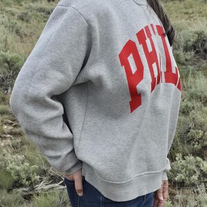 Side view of a gray oversized PHILA mockneck sweatshirt showing the relaxed oversized fit.