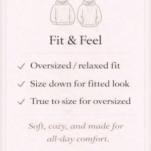 May include: A cream-colored graphic with illustrations of two hoodies and text describing the fit and feel. The text includes "Oversized / relaxed fit", "Size down for fitted look", and "True to size for oversized". The bottom text reads "Soft, cozy, and made for all-day comfort."
