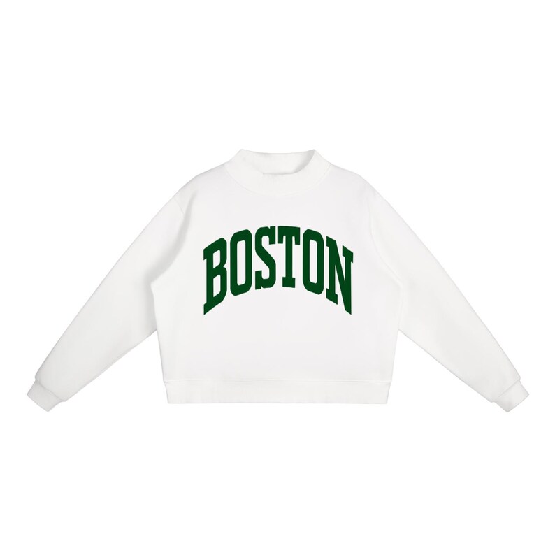 Op de afbeelding: Een wit sweatshirt met lange mouwen, een opstaande kraag en geribbelde boorden. Het woord BOSTON staat in een grote, donkergroene, gebogen lettertype in collegestijl op de borst gedrukt. Het kledingstuk heeft een strak en eenvoudig ontwerp.