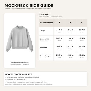Op de afbeelding: Een lichtgrijs sweatshirt met een opstaande kraag, verlaagde schouders en een relaxte pasvorm. De afbeelding bevat een maattabel met afmetingen in inches en centimeters voor de maten S, M en L, inclusief lengte, borstbreedte en mouwlengte.