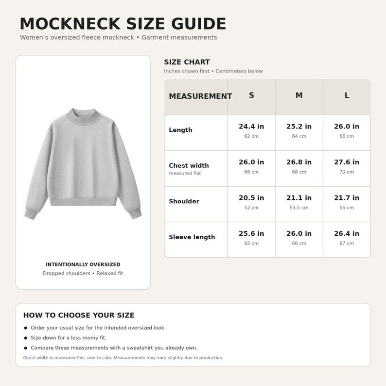 Op de afbeelding: Een lichtgrijs sweatshirt met een opstaande kraag, verlaagde schouders en een relaxte pasvorm. De afbeelding bevat een maattabel met afmetingen in inches en centimeters voor de maten S, M en L, inclusief lengte, borstbreedte en mouwlengte.