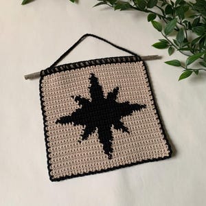 Modern crochet wall hanging pattern featuring a bold black eight-pointed star on a neutral background. This is a digital PDF pattern for instant download, not a finished product.