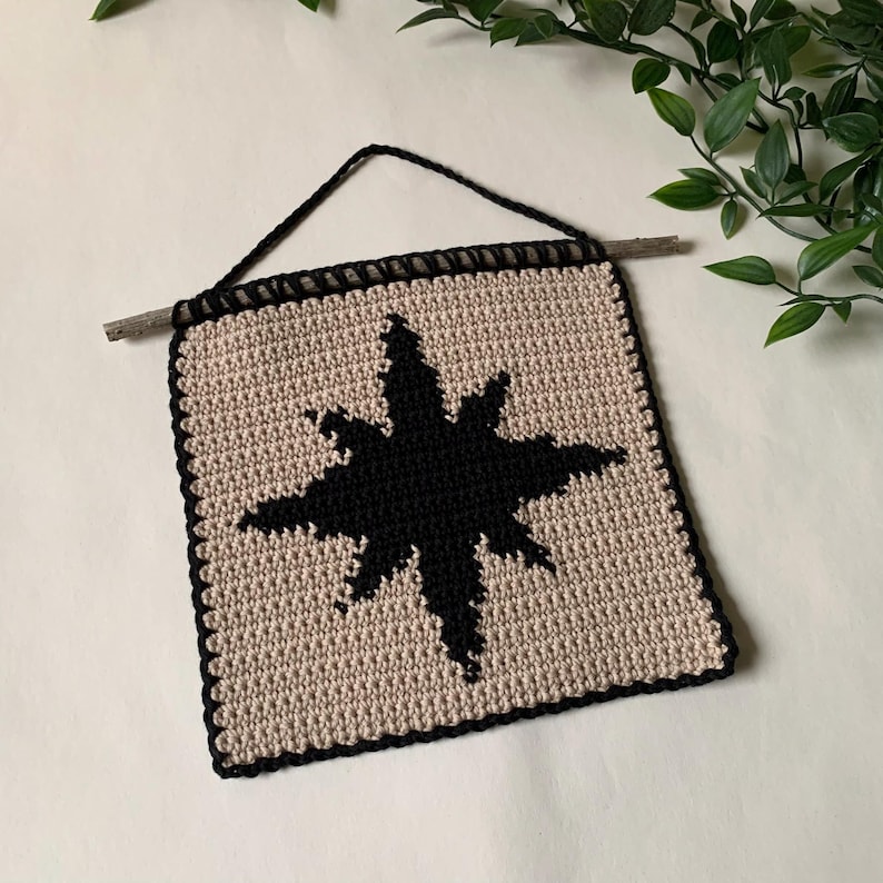 Modern crochet wall hanging pattern featuring a bold black eight-pointed star on a neutral background. This is a digital PDF pattern for instant download, not a finished product.