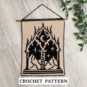 Könnte beinhalten: Ein cremefarbener und schwarzer Wandbehang aus Häkelarbeit mit einem gotischen Kathedralen-Design mit Mond- und Kreuzdetails. Das rechteckige Stück hat einen schwarzen Rand und eine Aufhängeschnur. Der Text "CROCHET PATTERN" befindet sich unten.