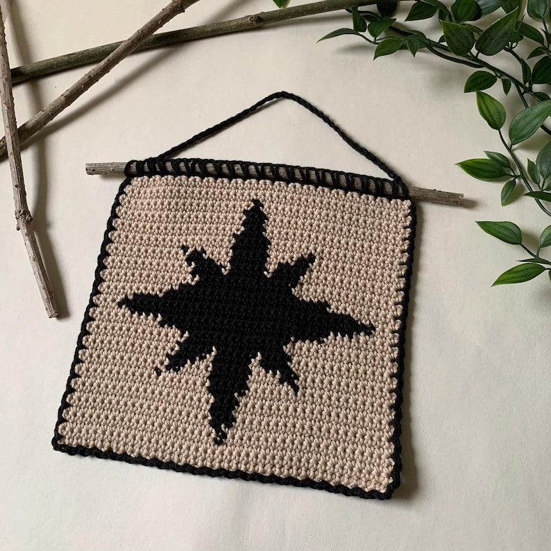 Modern crochet wall hanging pattern featuring a bold black eight-pointed star on a neutral background. This is a digital PDF pattern for instant download, not a finished product.