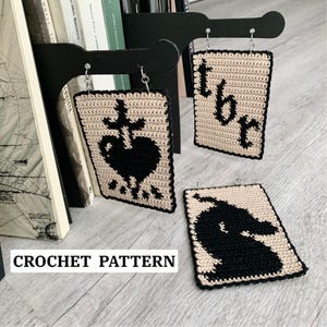 Könnte beinhalten: Handgefertigte Häkelohrringe mit schwarzen und beigen rechteckigen Designs. Ein Ohrring zeigt ein schwarzes Herz mit Kreuz, ein anderer die Buchstaben "tbr", und der dritte eine schwarze Silhouette. Der Text "CROCHET PATTERN" ist unten.